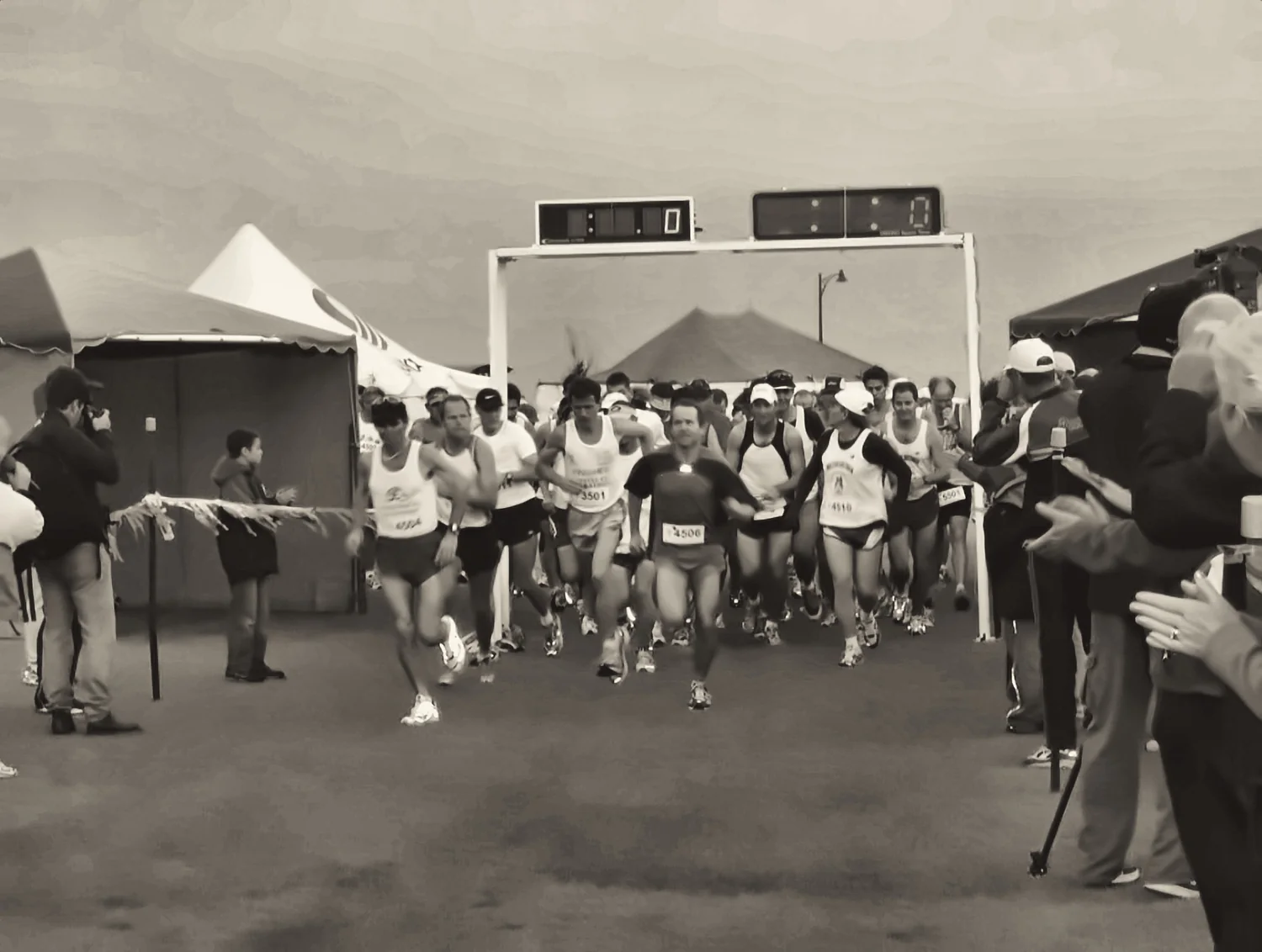 The field crossing the start line beneath the timing gantry.